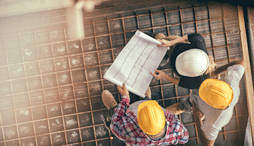 three construction workers looking at a blueprint
