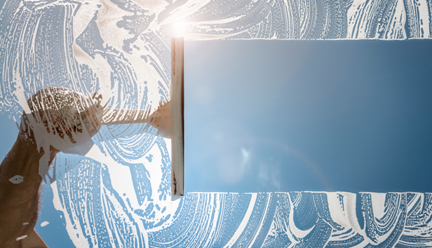 Window cleaner using a squeegee to wash a window