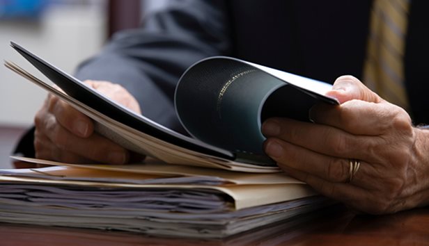 Shows a person reading a document about employee benefits