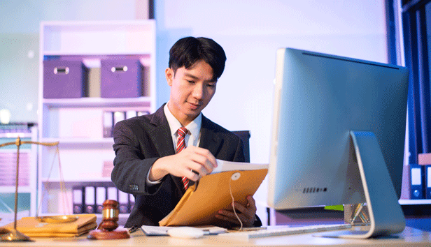 man reviews judicial records in front of a computer