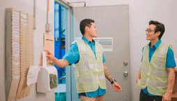 One employee clocks in while talking to another