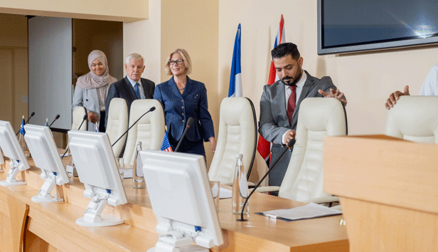 A group of elected officials assume their seats at the dais