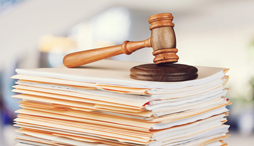 A gavel sitting on top of a stack of legal documents
